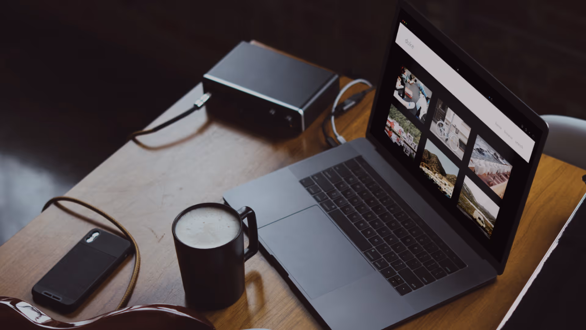 Angled overhead view of a desktop with an open laptop showing a custom SmugMug website.